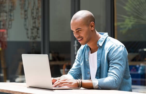 image of a smiling man working on his laptop